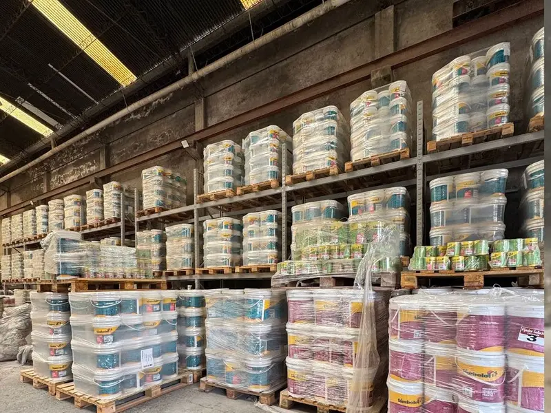 Pallets de pintura y productos de obra apilados en altura en el depósito de CASASILVIAWEB