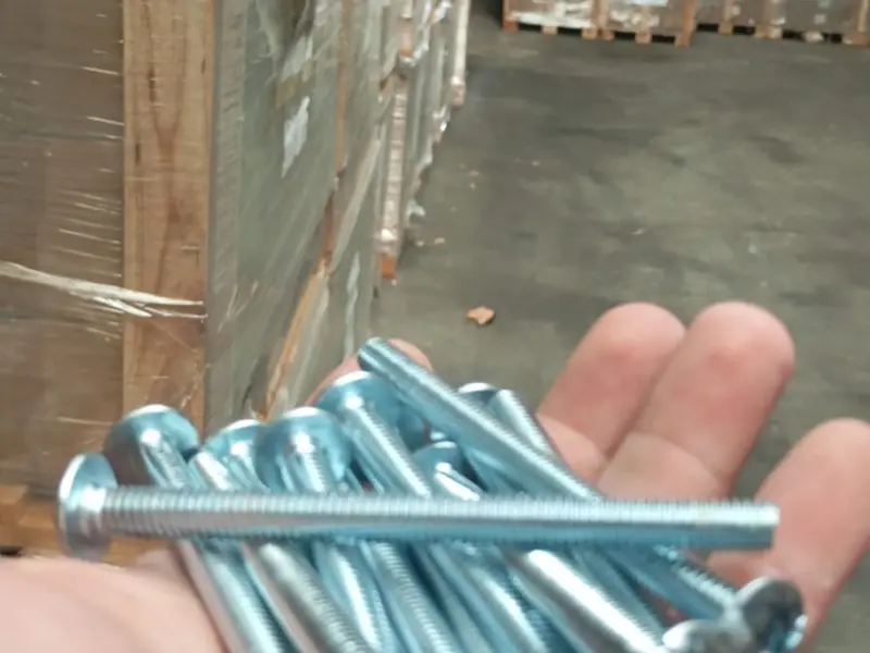 Tornillos y fijaciones junto a pallets de mercadería en el depósito
